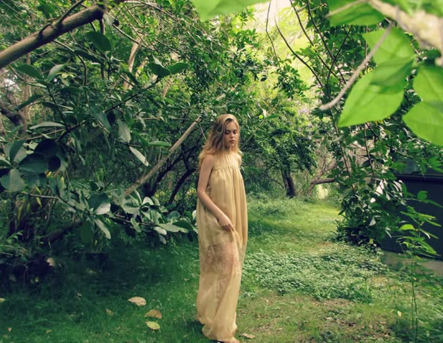 A woman standing in a lush garden